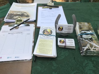 South Jersey Quail Project brochures, business cards, and sign up sheets sitting on a green tablecloth.